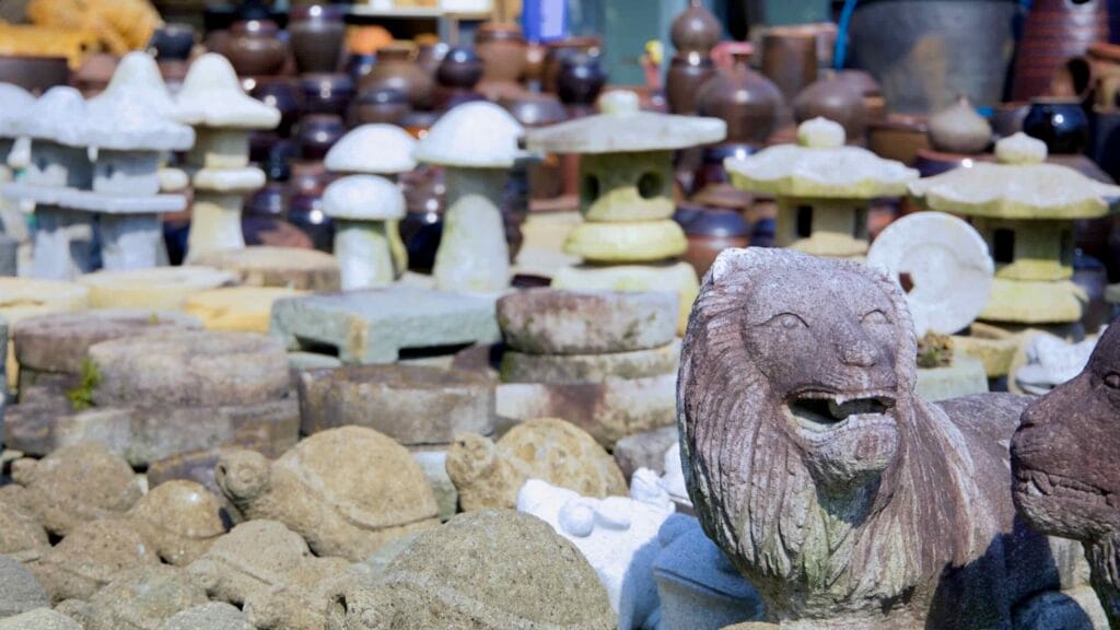 A collection of handcrafted stone sculptures, including turtles, lanterns, and a lion.