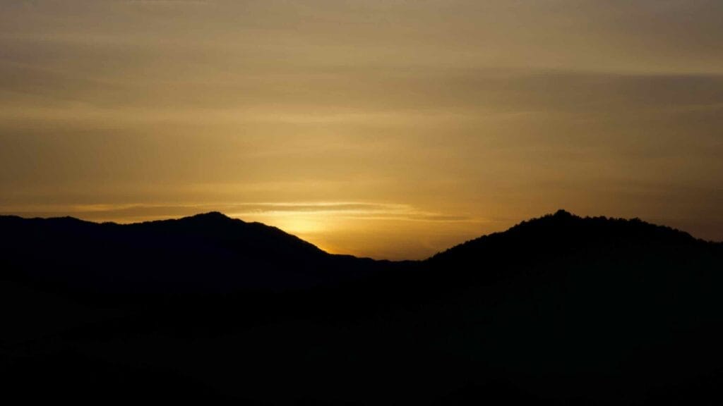 Golden sunset illuminating the rolling mountains along the Seomjingang Bike Path.