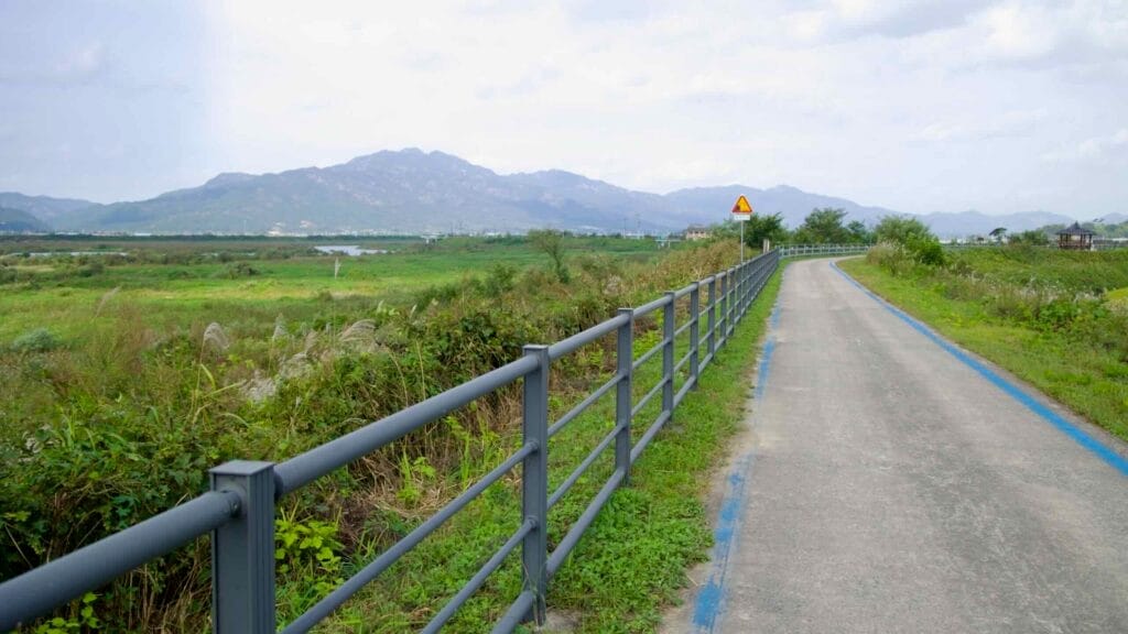 Seomjingang Bike Path by the river, with greenery and mountain views.