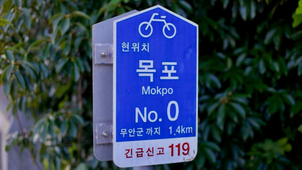 A blue kilometer zero marker sign designates the official starting point of the Yeongsangang Bike