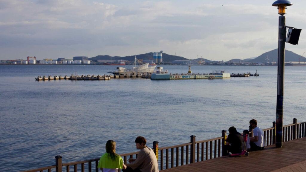 Visitors relax near the Mokpo Dancing Sea Fountain boardwalk on the waterfront.