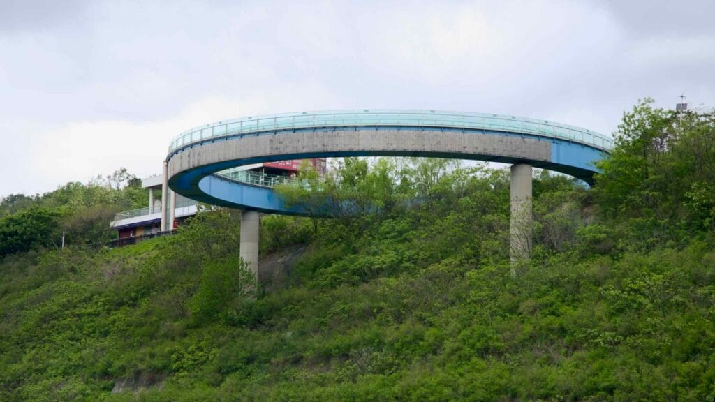 Ara Observatory’s elevated glass-bottomed skywalk curves above the forested hillside.