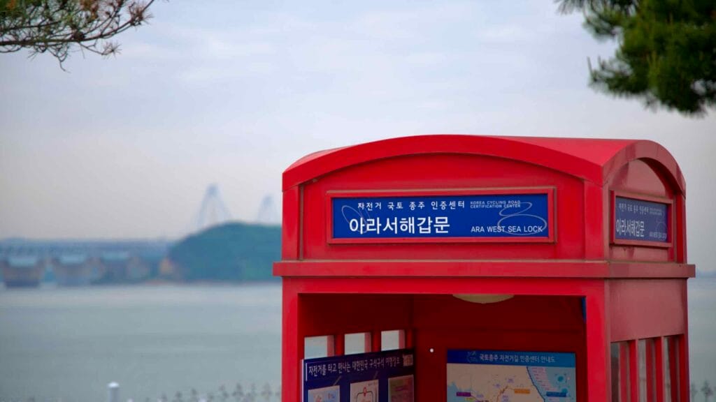 Red phone-booth style Ara West Sea Lock certification center stands above the Gyeongin Ara Waterway, marking the start of Korea’s cross-country bicycle route.