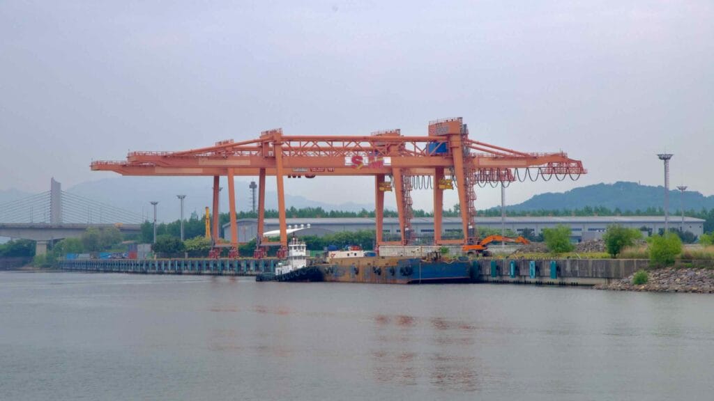 Massive orange cranes operated by the SM Group line the dockside at Ara Port Terminal.