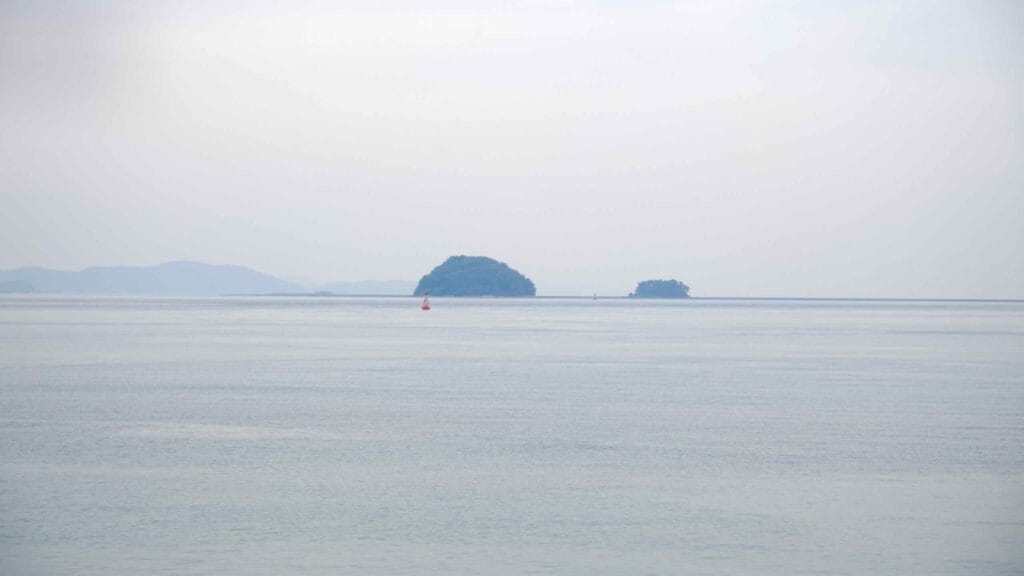 Two small islands rise from the calm waters of the Yellow Sea, seen from the coast near Jeongseojin at the western edge of the Ara Waterway, where Korea’s Cross-Country Cycling Path begins.