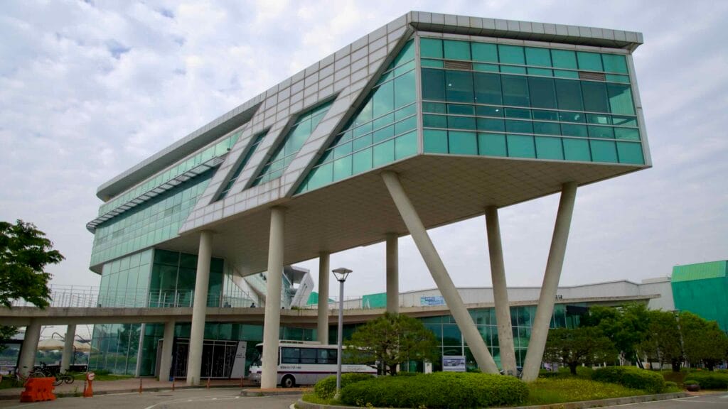 The striking triangular support columns and glass design of the Ara Gimpo Passenger Terminal stand above the main entrance and bus turnaround near the Ara Waterway.
