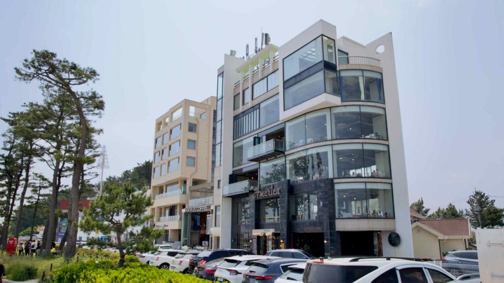 Multi-level glass-fronted cafe on busy Gangneung Coffee Street.