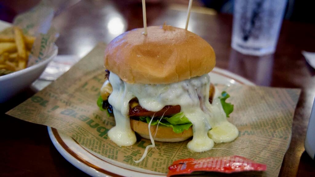 Cheeseburger with melted cheese, lettuce, and tomato, served with fries at Burger Paul & Mary.
