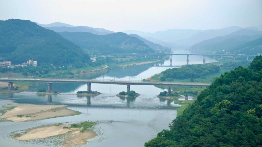 Gong Mountain Fortress shows two parallel bridges crossing the Geum River, with forested slopes and sandbanks.