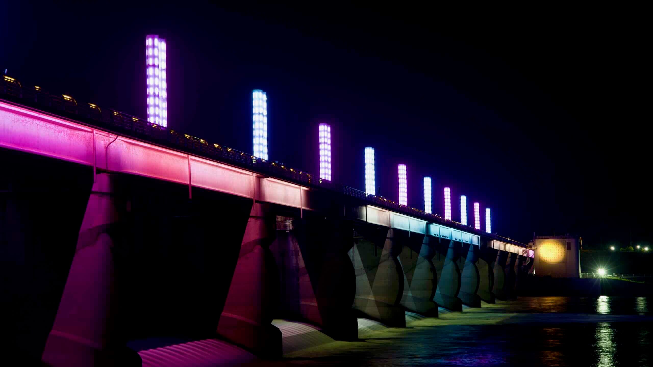 Pink, purple, and blue lights illuminates Yeoju Weir and its cascading gates.