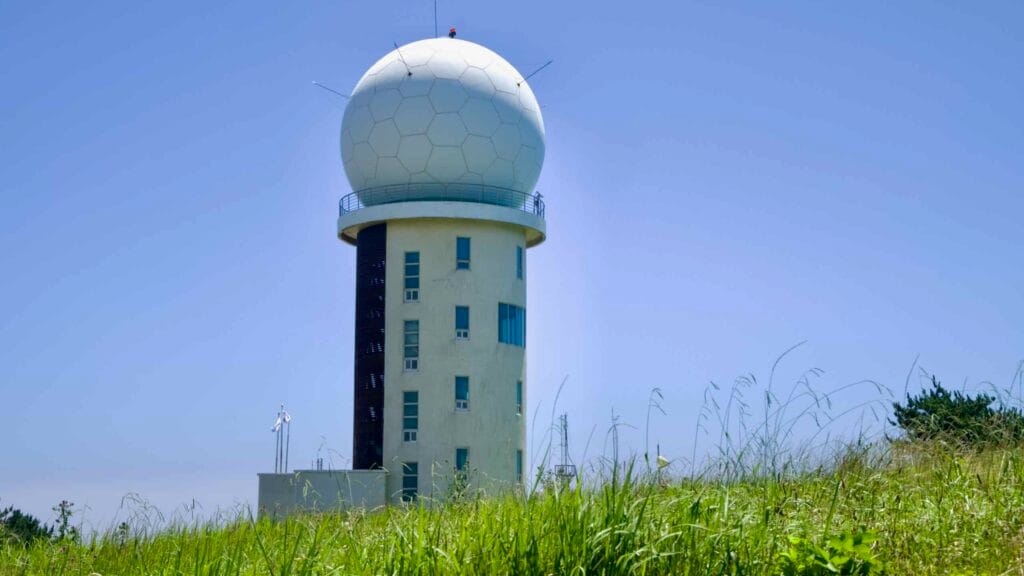 KMA’s Gosan Weather Radar Observatory rises over Suwolbong’s grasslands.