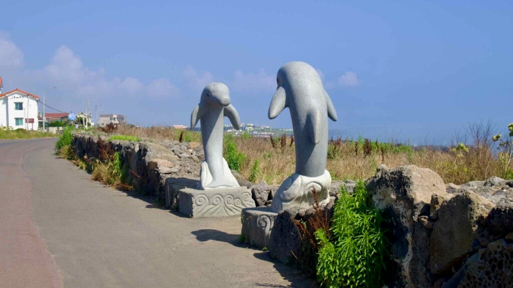Stone dolphin statues along Yeongnak Coastal Road near Sindo.
