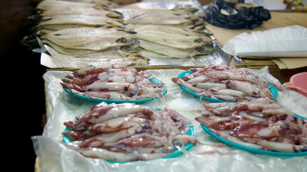 Fresh squid stacked on trays at Daejeong Five‑Day Market.