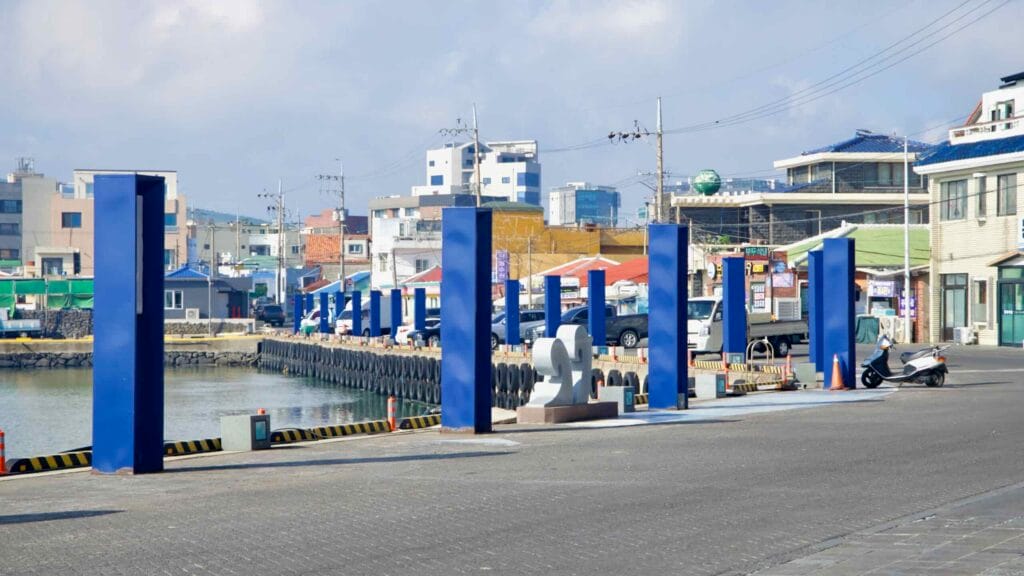 Blue columns and sculpture along the quay at Moseulpo Port.