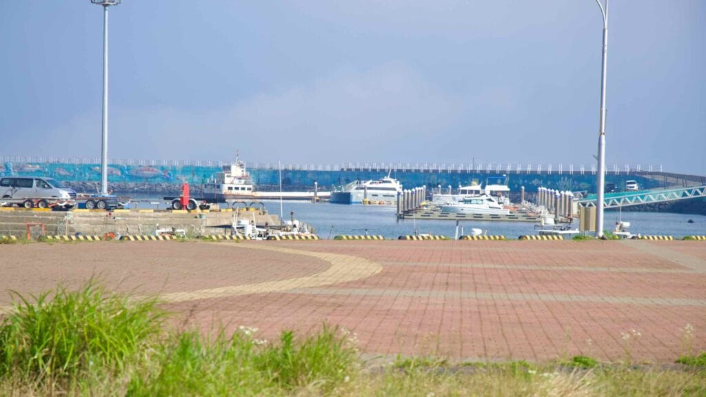 Boats at Unjin Port with floating piers and a long breakwater.