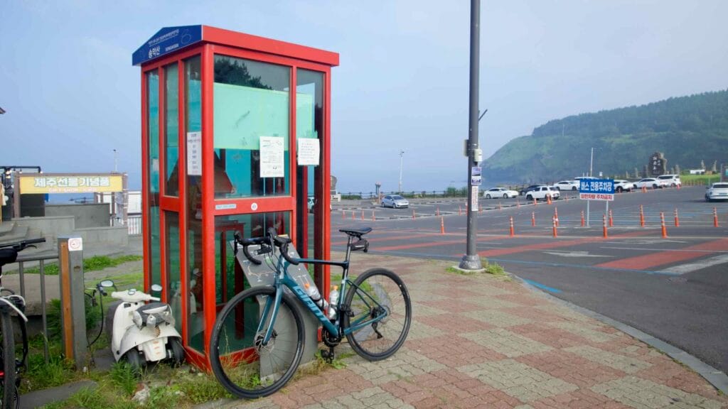 A touring bicycle leans beside the red Korea Cycling Road Certification Center.