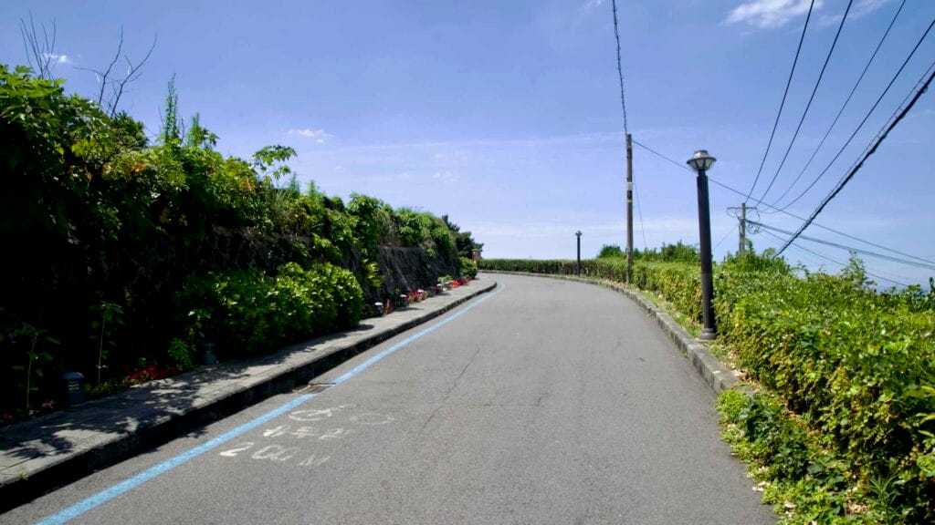 Coastal bike‑route blue line climbs a lane near Yongduam.
