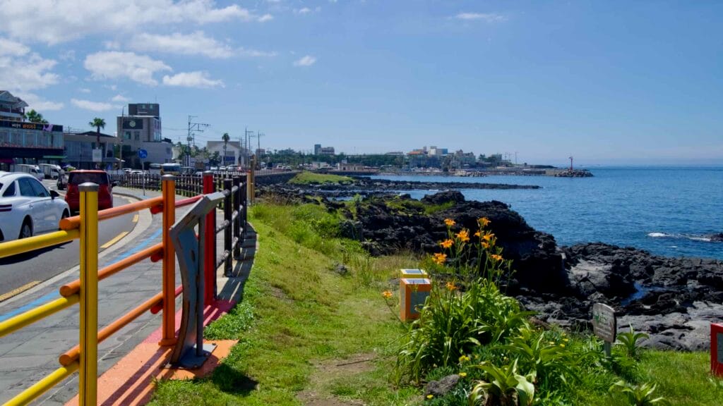 Rainbow railings and basalt shore along the Hagu‑Aewol coast.