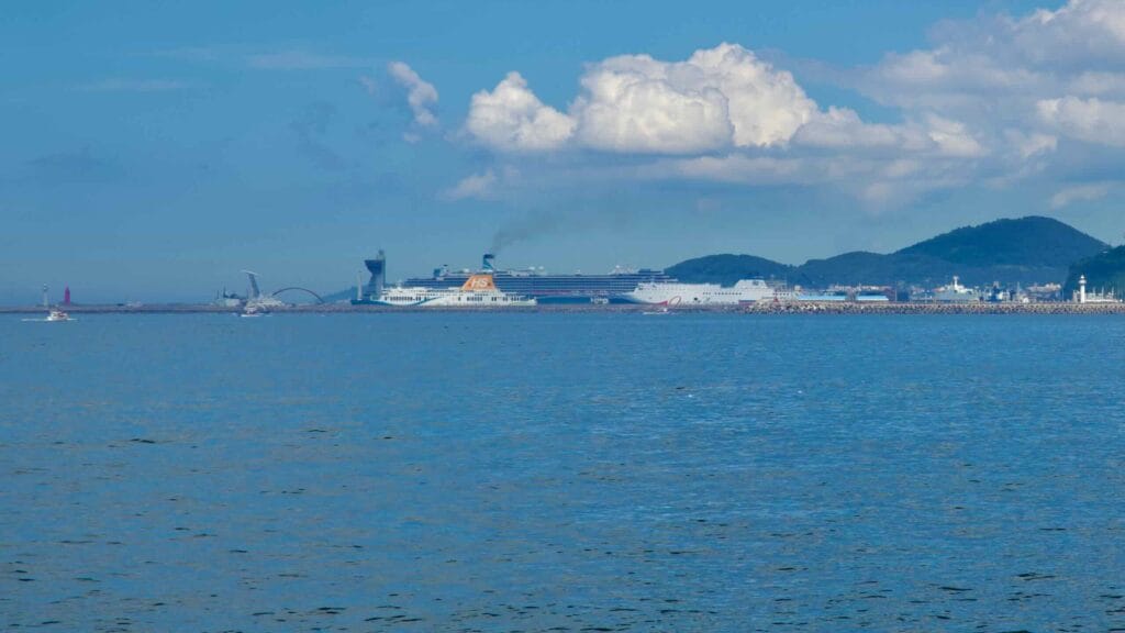Jeju International Ferry Terminal and port district viewed across open water.