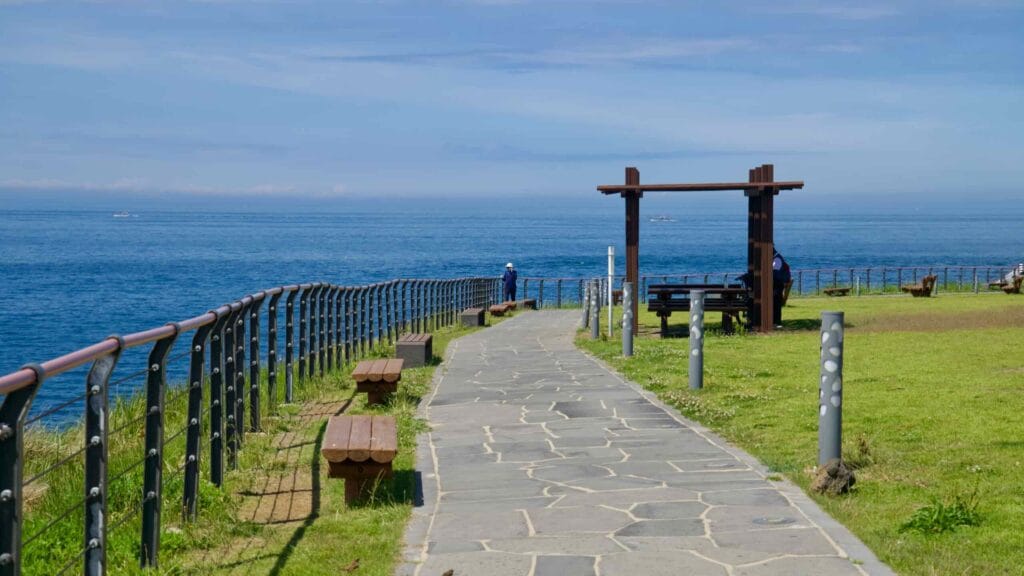 Curving coastal path with benches and a pergola at Eoyeong Park.