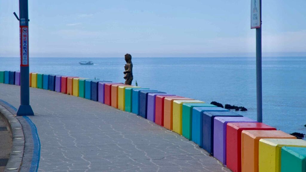 Curving rainbow seawall along the pedestrian path by the sea on Jeju Rainbow Coastal Road.