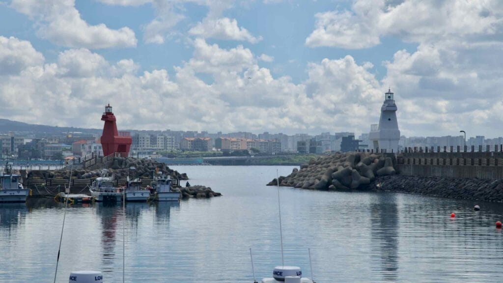 Small fishing boats moor between Iho Port’s playful horse‑shaped lighthouses.
