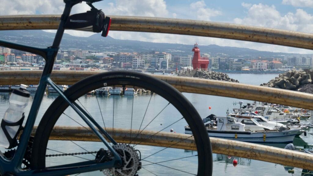 A road bike rests against railings on the breakwater overlook above Iho Harbor.