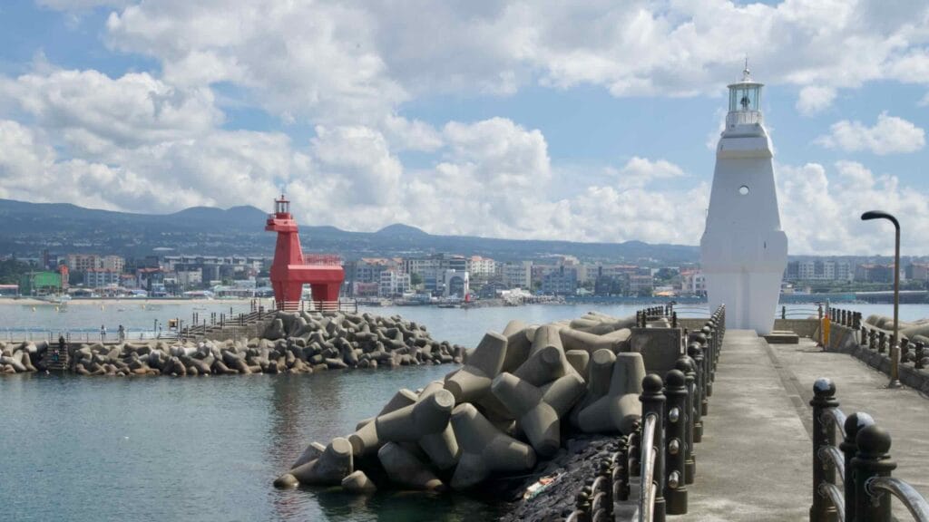 Along the Iho Port breakwaters showing the white and red horse‑shaped lighthouses.