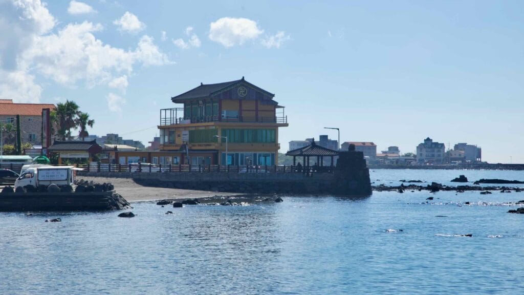 Temple‑style building and pavilion on a lava rock point.