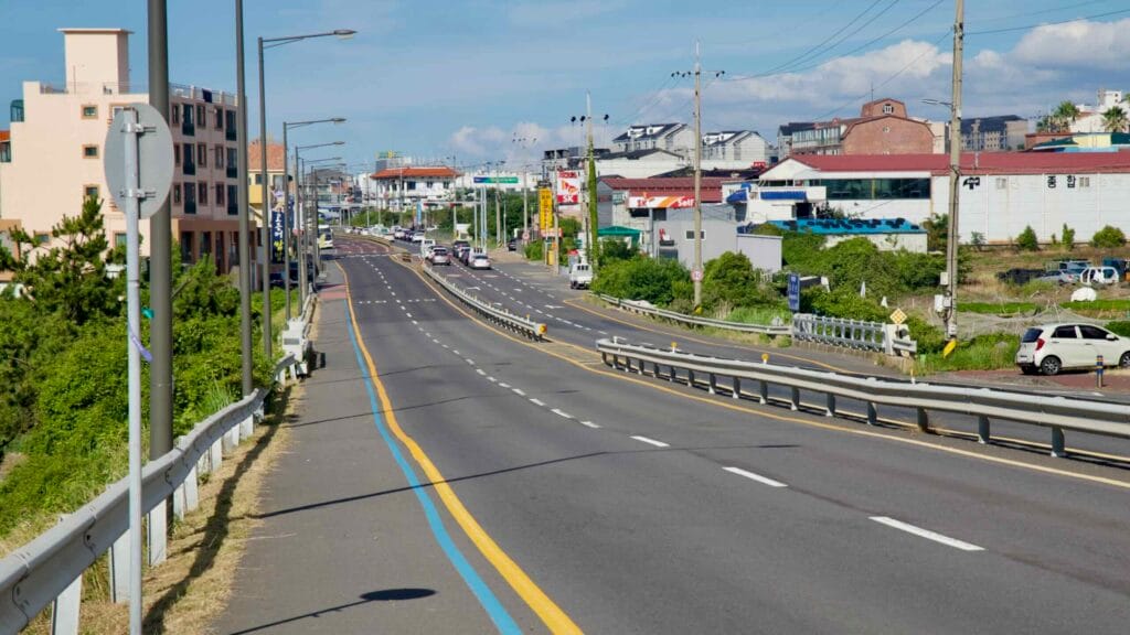 Arterial road with bike line through Jeju’s outskirts.