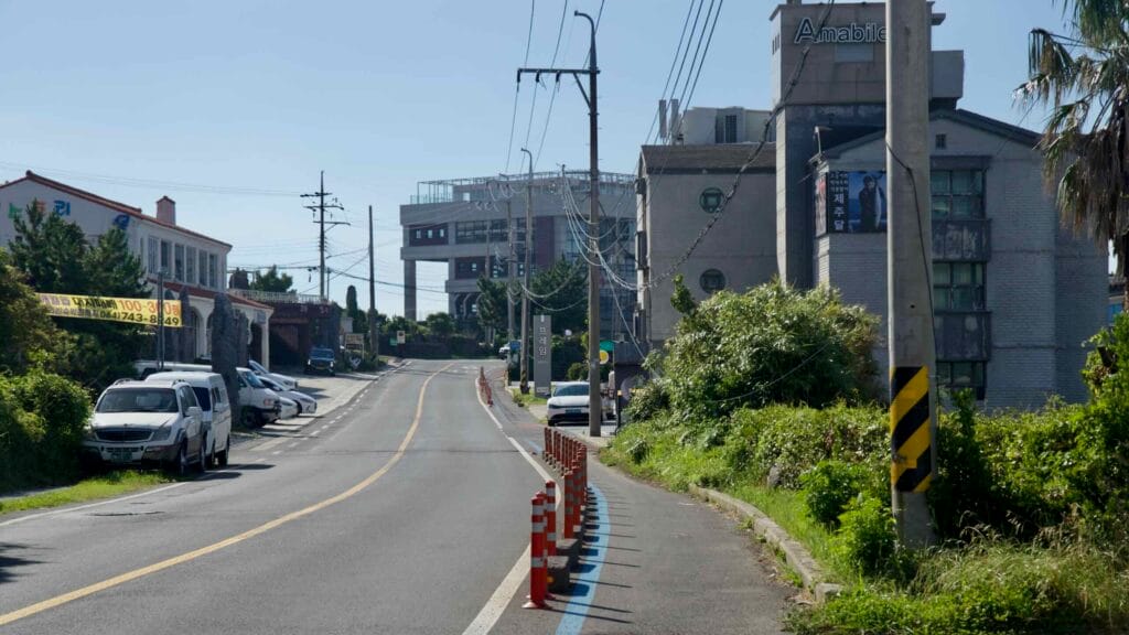Uphill stretch near Gamundong Port with separated bike lane and orange posts.