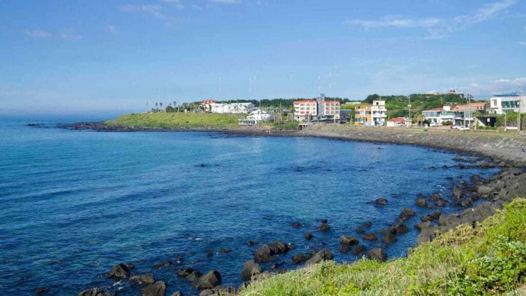Gueom Bay with curving seawall and village along Jeju’s northwestern coast.