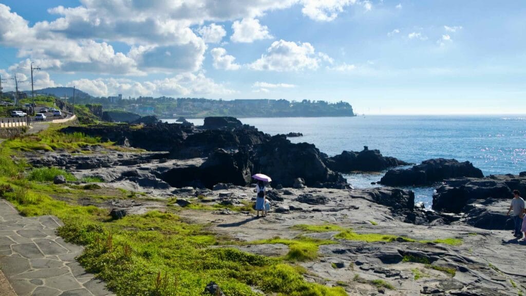 Breakwater and calm water beside layered lava platforms at Gueom Port.