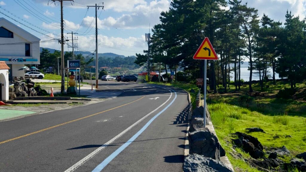 Bike route by a GS25 and pine grove along the Hagu-Aewol Coastal Road.