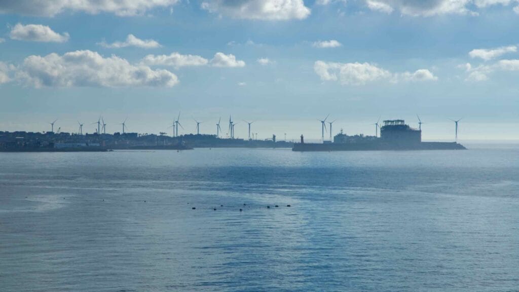 Distant wind turbines and industrial complex across the bay from Aewol.