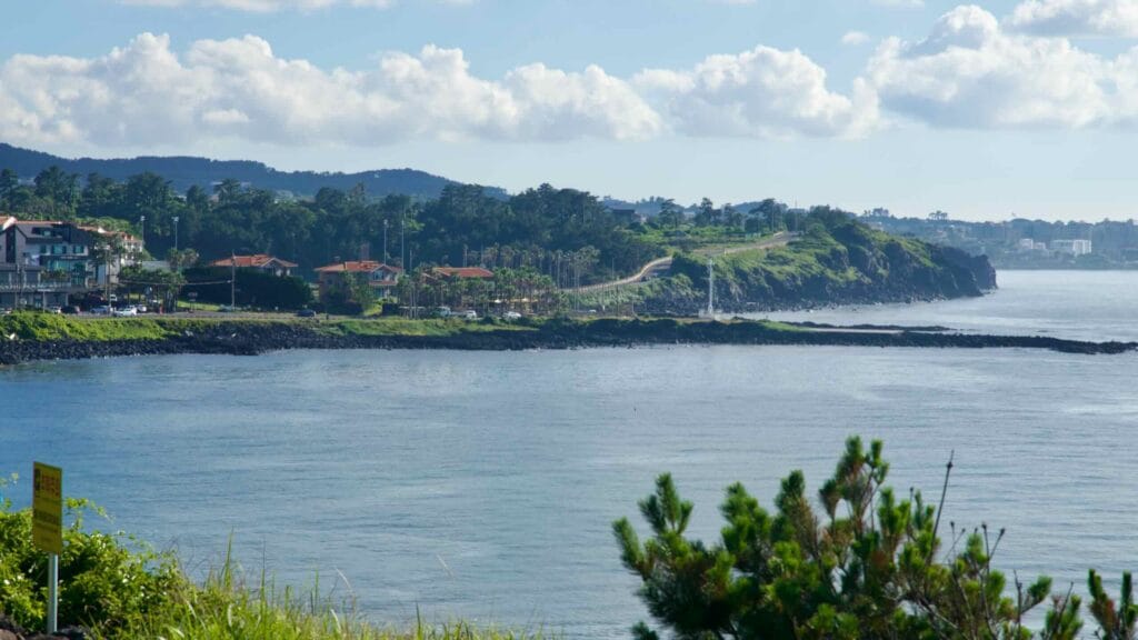 A view toward a green headland along the Hagu‑Aewol Coastal Road.