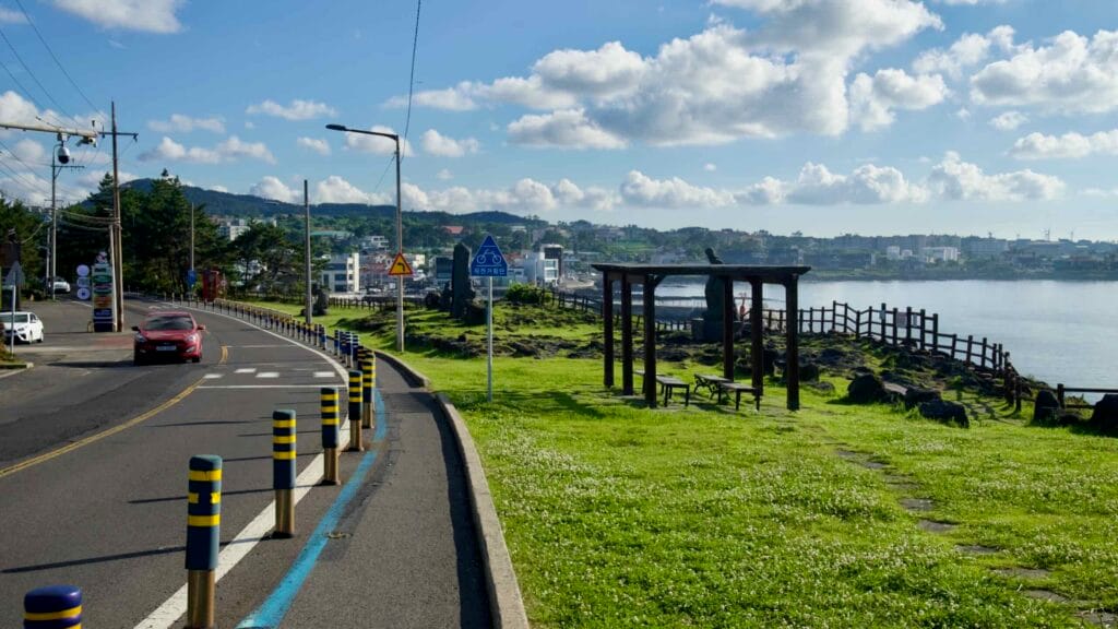Bollard‑protected bike lane and roadway pass Darak Shelter.