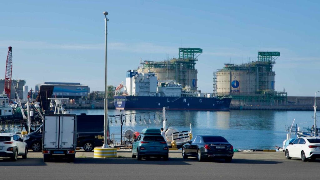 An LNG carrier docks inside Aewol Port, framed by cranes.