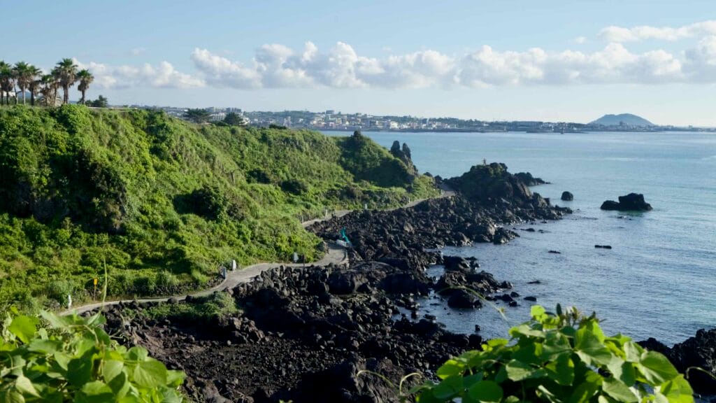 The Handam Coastal Trail winds beneath lush, green cliffs near Handam Coastal Trail.