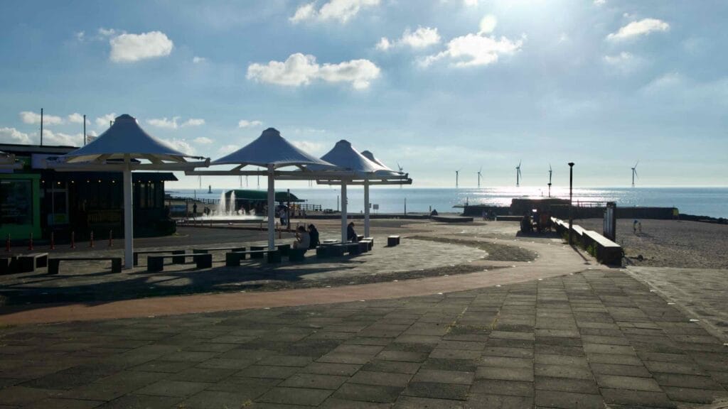 At Gwakji Beach, white shade canopies and a plaza face the beach.