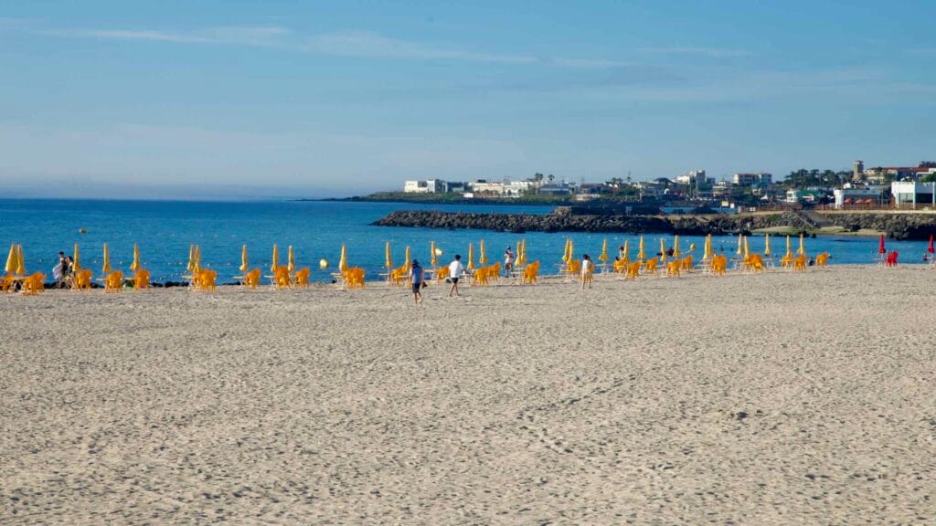 Rows of yellow beach umbrellas and chairs line the sand at Gwakji Beach.