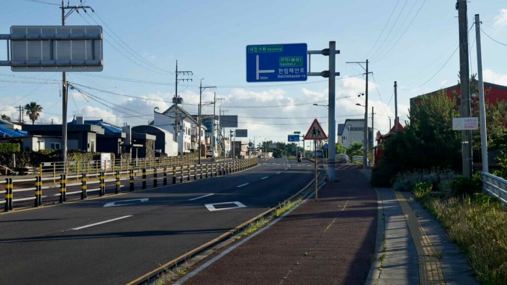 Hallimhaean‑ro near Gwideok with bike lanes, sidewalks, and a bright blue sky.