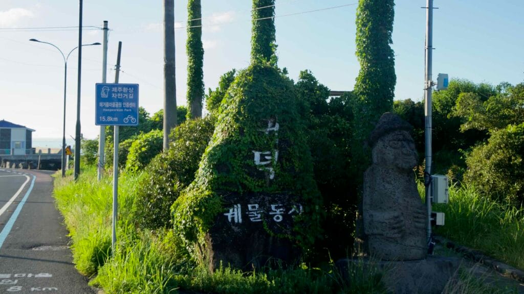 Dolharubang and ivy‑covered marker at the entrance to Gudeok‑Gwet Garden in Gwideok.