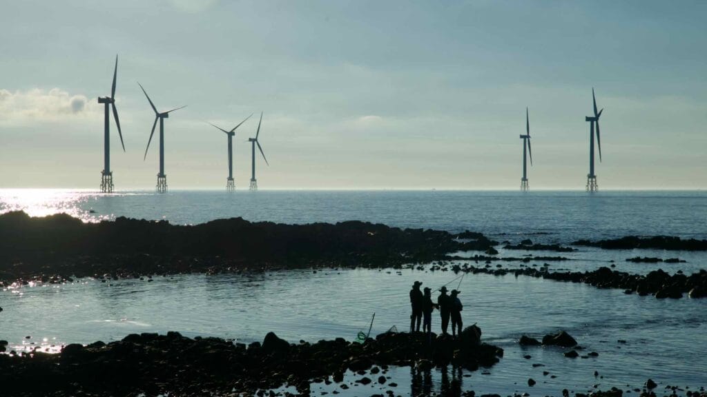 Shore anglers with offshore wind turbines off Gwideok Village at low tide.