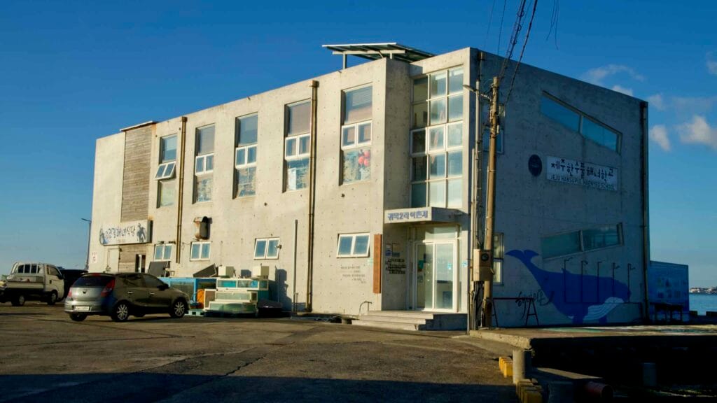 Jeju Hansupul Haenyeo School building on the waterfront with whale mural.