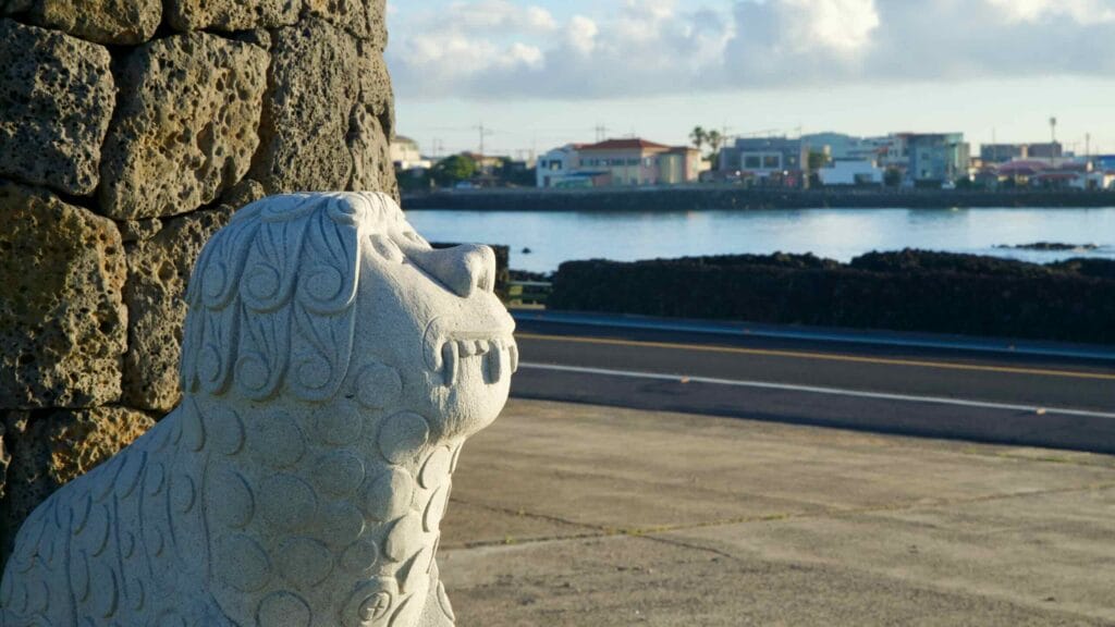 Stone statue beside a temple overlooking the harbor at Gwideok Village.