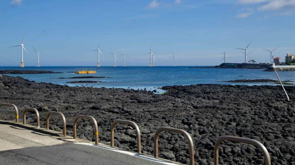 Offshore windmills beyond Jeju’s basalt shore near Hanlim.