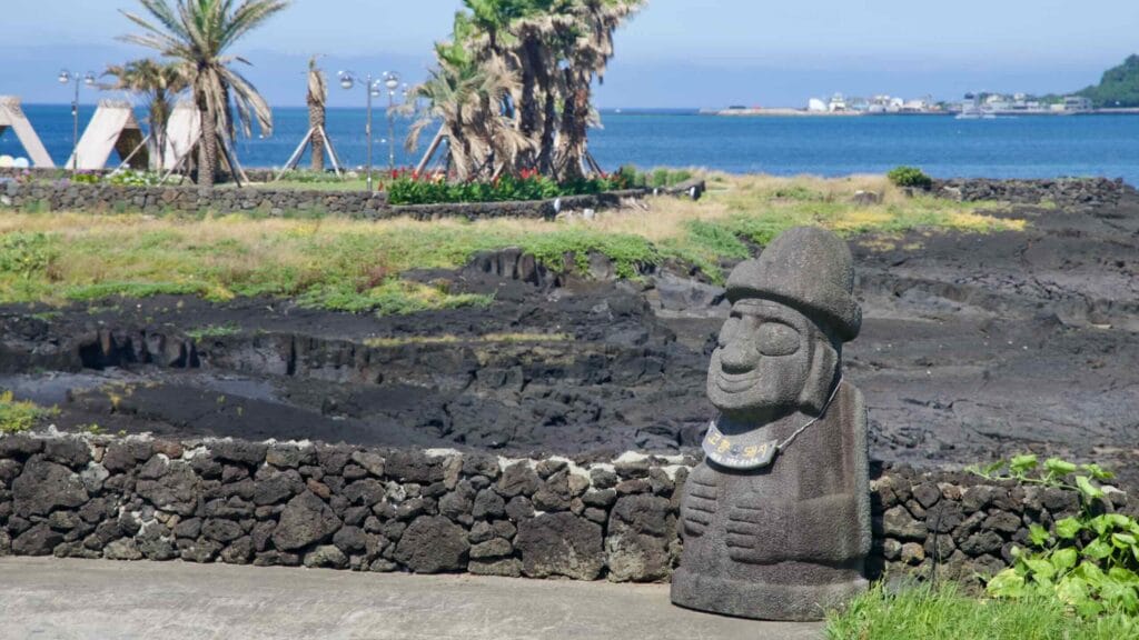Dol hareubang statue overlooking the lava shore near Hanlim.