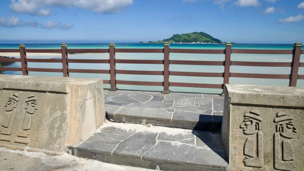 Hyeopjae Beach steps with dol hareubang carvings and Biyangdo view.