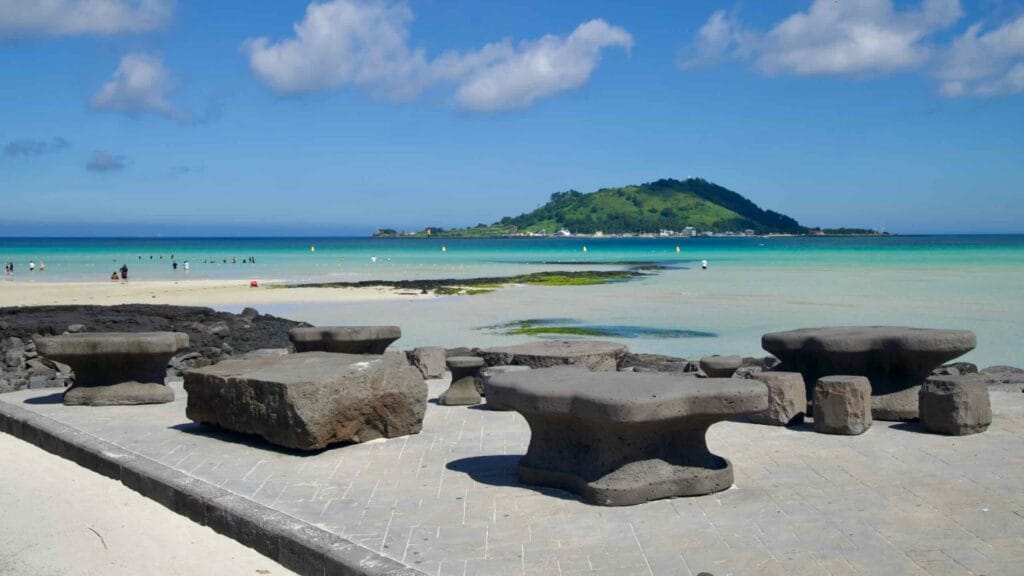 Basalt picnic tables on the Hyeopjae promenade facing Biyangdo.
